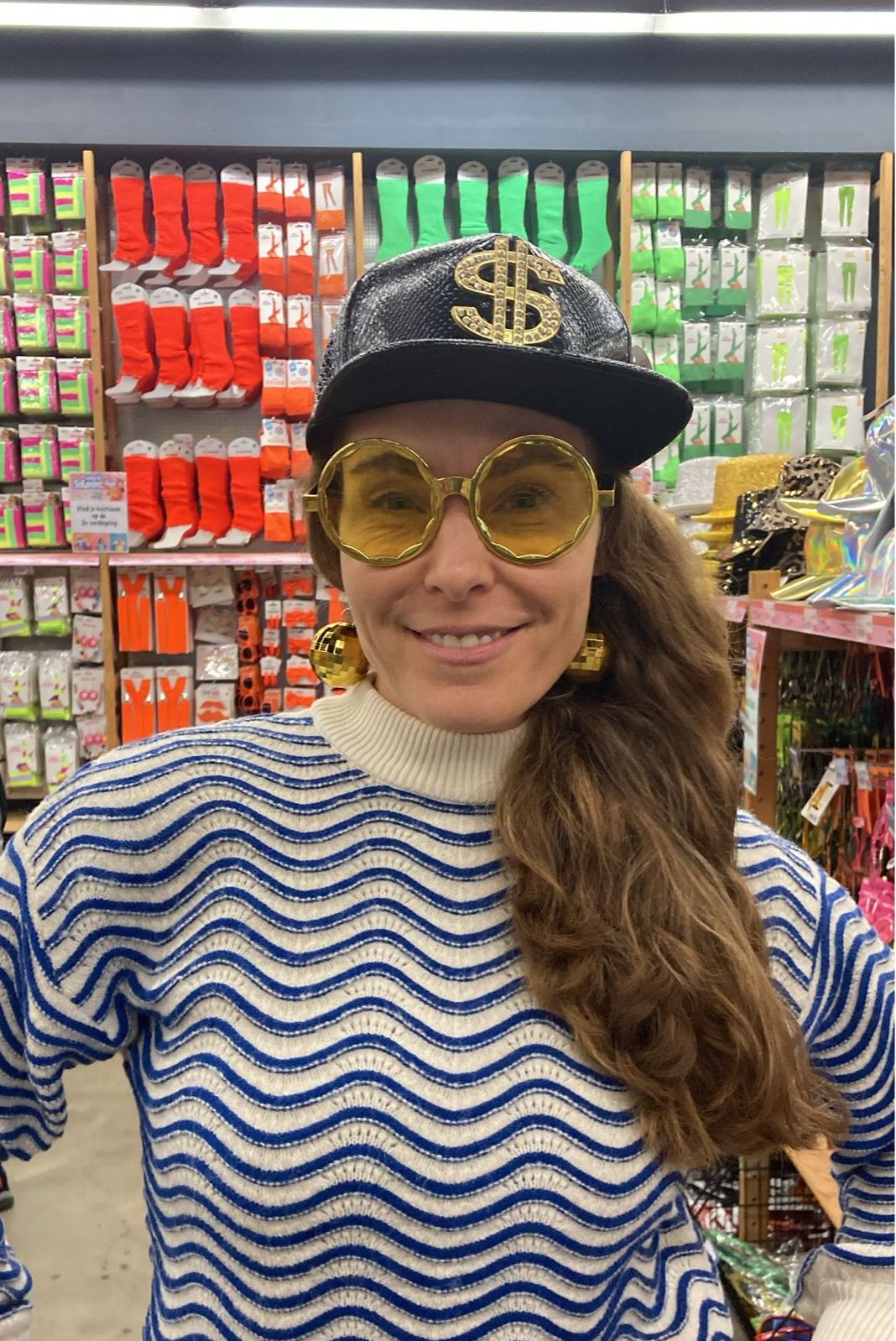 Grandma wearing a black cap and gold glasses in a colorful shop